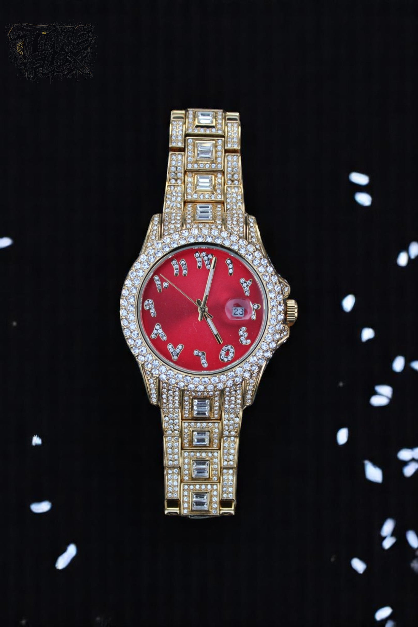 Gold-tone unisex watch with a red dial, crystal-encrusted bezel, and rectangular stones on the band. The watch features sparkling Roman numeral markers and a date display, offering a luxurious and eye-catching design.
