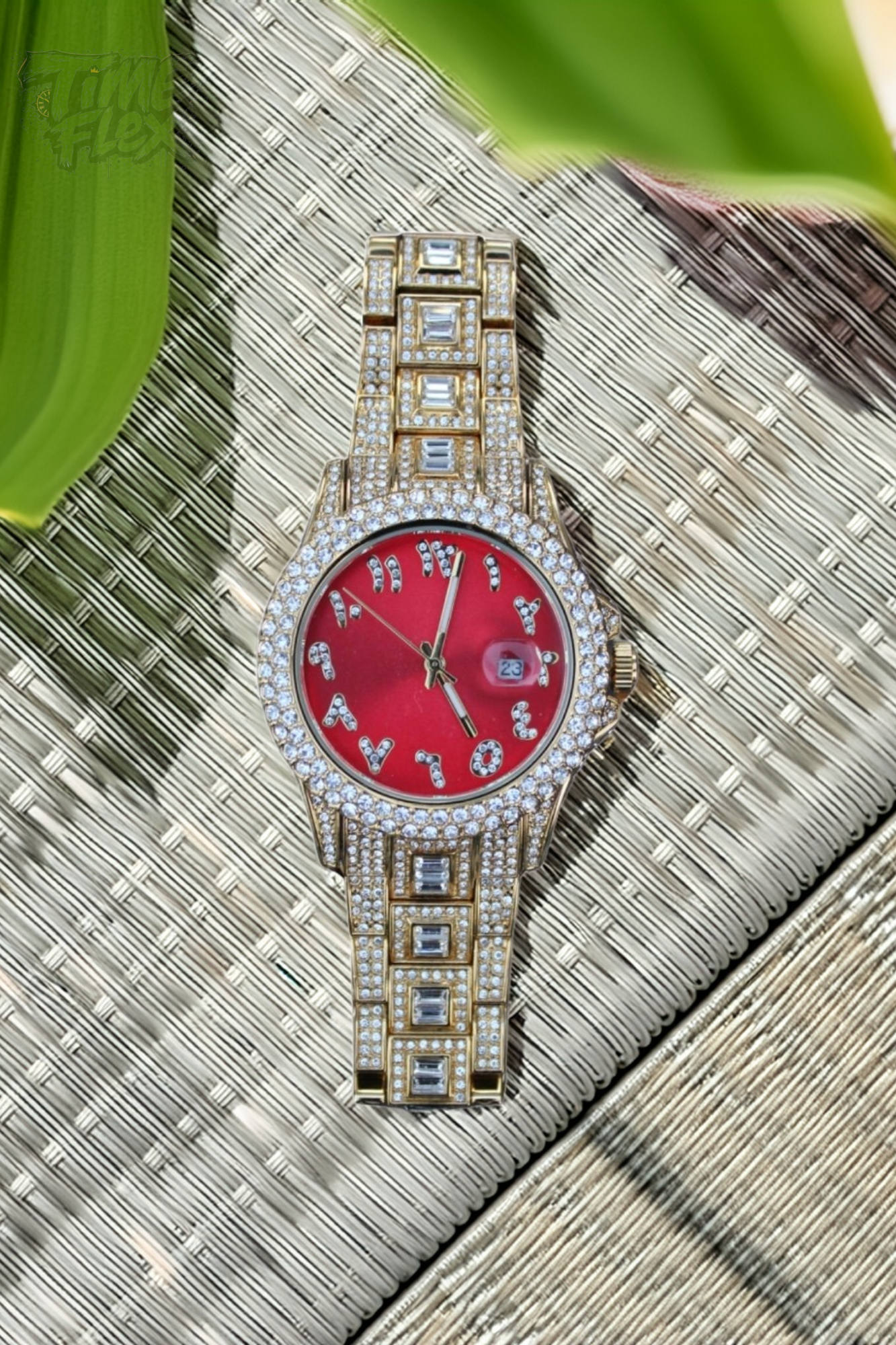 Gold-tone unisex watch with a red dial, crystal-encrusted bezel, and rectangular stones on the band. The watch features sparkling Roman numeral markers and a date display, offering a luxurious and eye-catching design.