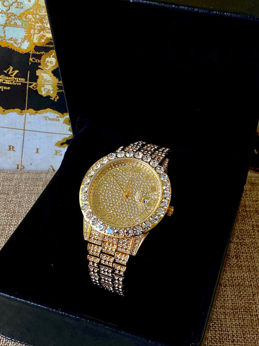 Gold-tone women's and men's watch with a diamond-studded bezel and a sparkling crystal-encrusted band. The watch features a textured gold dial, Roman numeral markers, and a date display at the 3 o'clock position, offering a luxurious and elegant look.