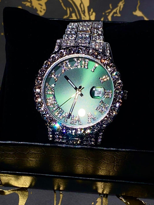Silver iced-out watch with emerald green dial, Roman numerals, and diamond bracelet – luxury streetwear timepiece