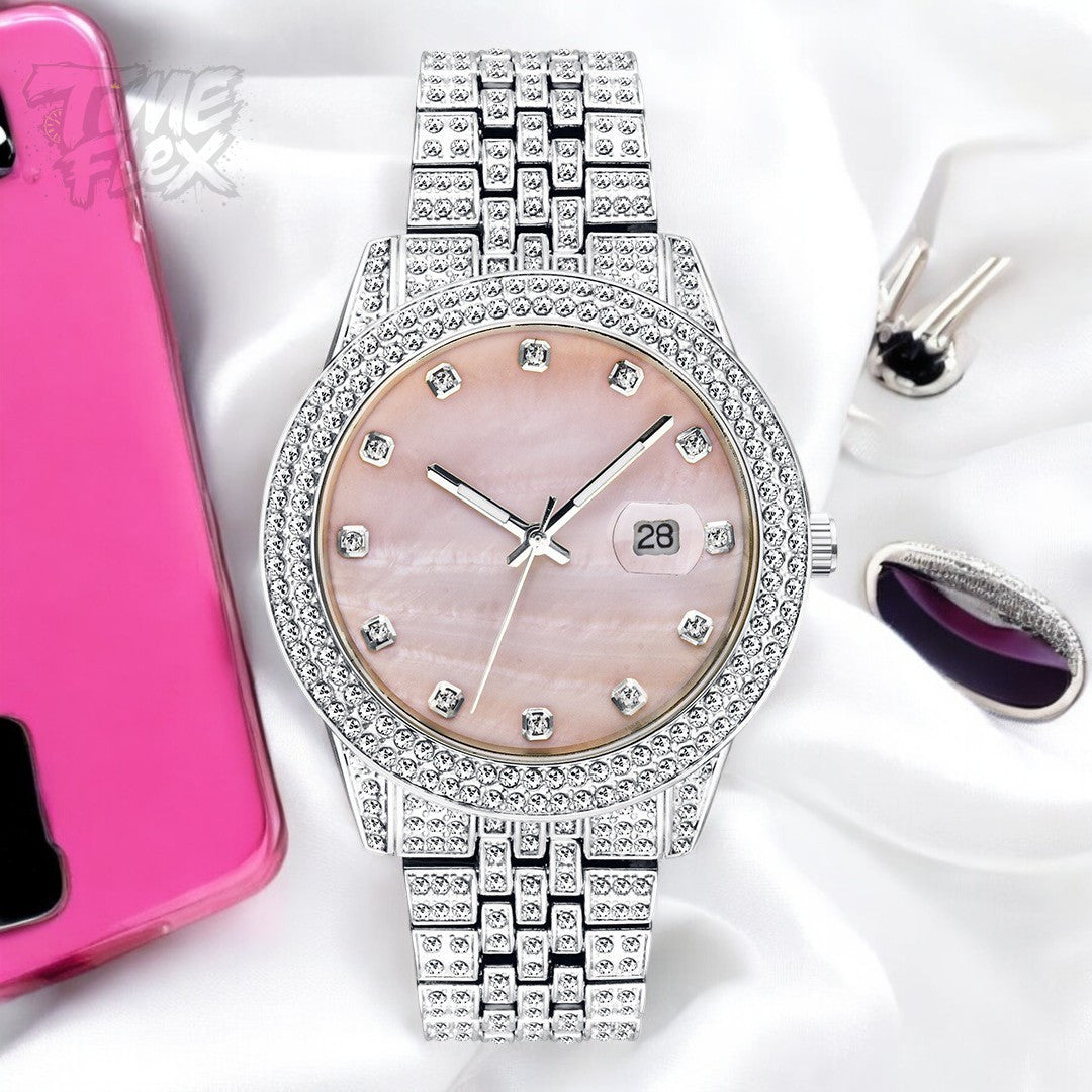 Silver-tone women's watch with a diamond-studded bezel, pink mother-of-pearl dial, and date display at the 3 o'clock position. The watch features a shiny, crystal-encrusted band for a luxurious finish.