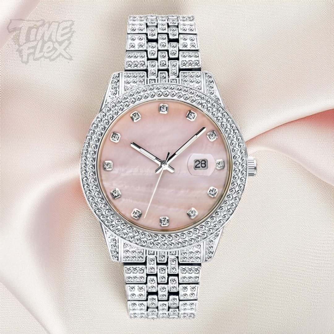 Silver-tone women's watch with a diamond-studded bezel, pink mother-of-pearl dial, and date display at the 3 o'clock position. The watch features a shiny, crystal-encrusted band for a luxurious finish.
