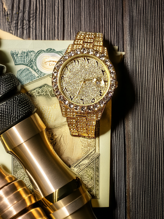 Gold-tone unisex watch with a sparkling, diamond-studded bezel and crystal-encrusted band. The watch features a glittering gold dial with unique Roman numerals and a date display, offering a luxurious and eye-catching look.