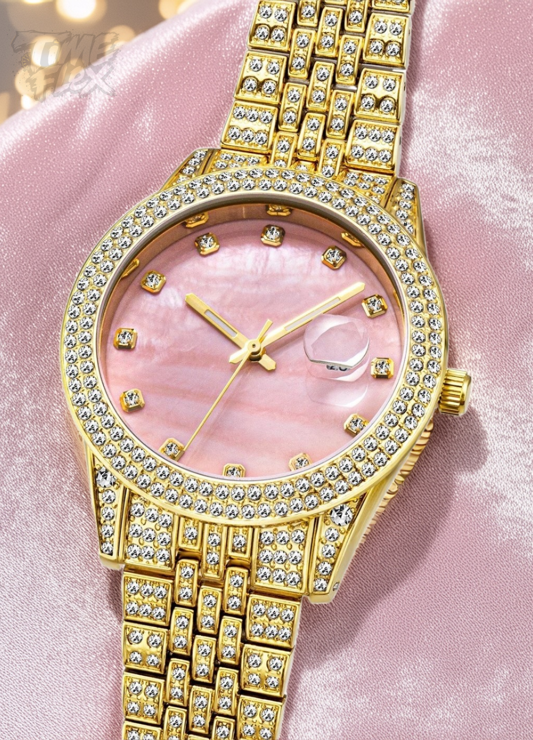 Gold-tone women's watch with a diamond-studded bezel, pink mother-of-pearl dial, and date display at the 3 o'clock position. The watch features a shimmering, crystal-encrusted gold band for a glamorous and luxurious look.