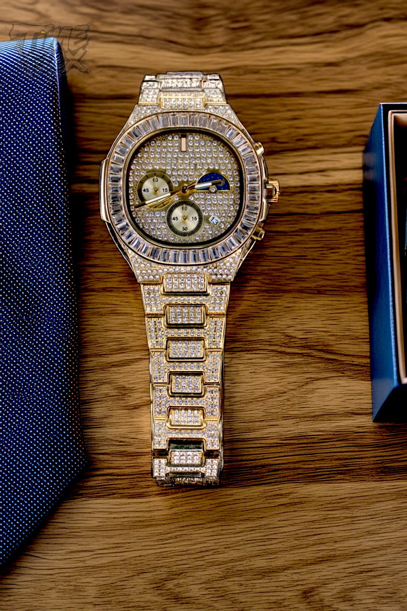 Gold-tone unisex watch with a diamond-studded dial and bezel. The watch features dual sub-dials, a moonphase display, and a sparkling crystal-encrusted band, offering a luxurious and high-end look.