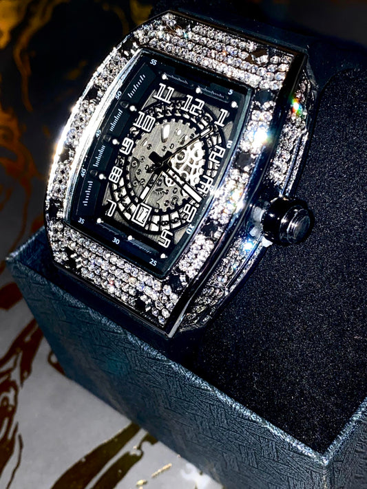 Black iced-out barrel watch with skeleton dial and rubber strap – luxury streetwear style