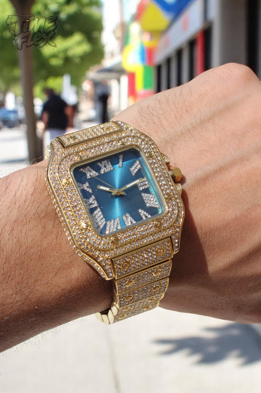 Gold iced square watch with blue dial and Roman numerals on luxury cream pillow – Aqua Empire 40MM by Time Flex