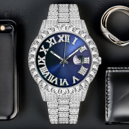 Silver-tone women's watch with a diamond-studded bezel and Roman numeral markers on a blue dial. The watch features a date display at the 3 o'clock position and a sparkling, crystal-encrusted band for a sophisticated, luxurious look.