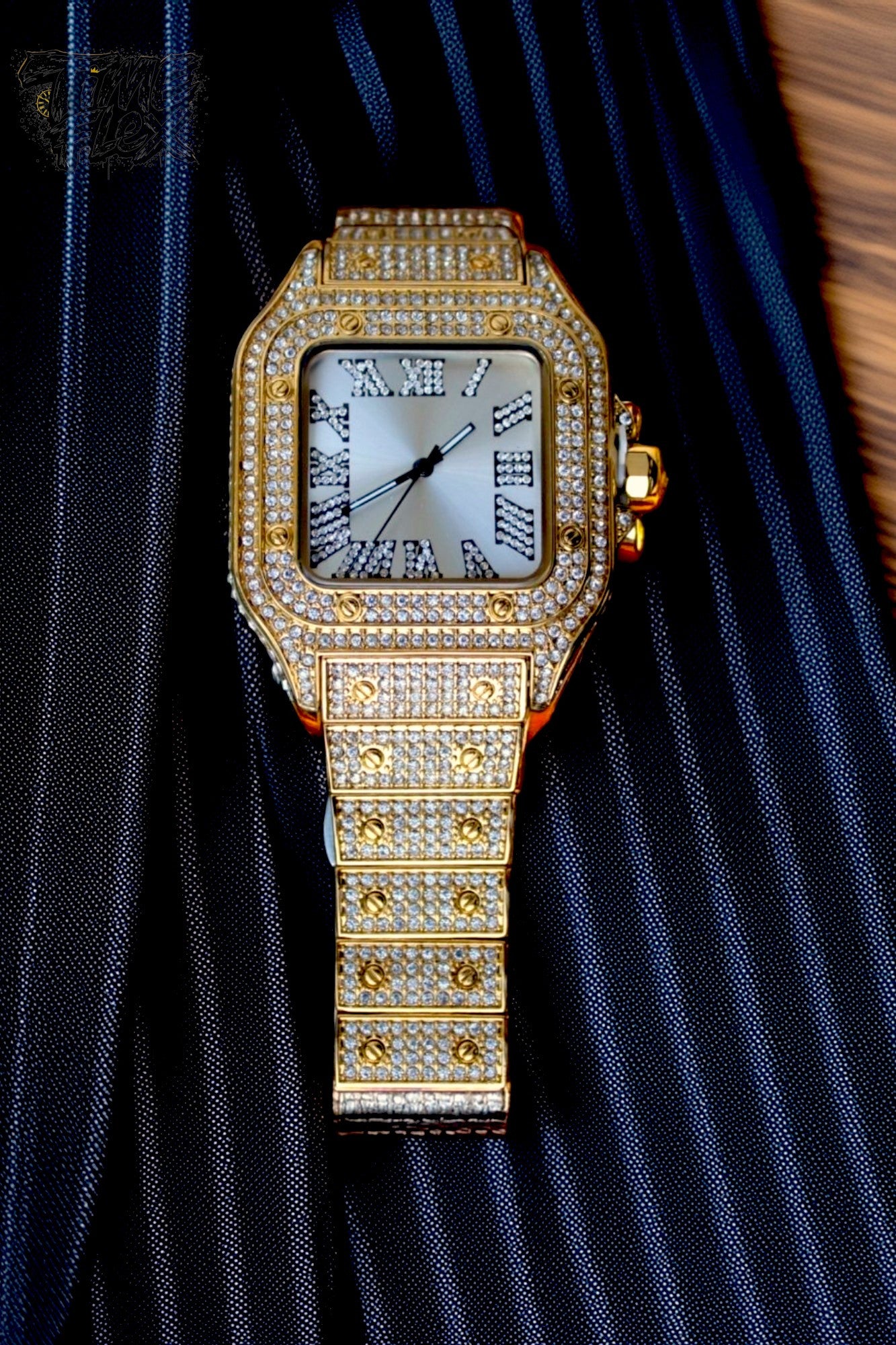 Gold-tone unisex watch with a square dial, diamond-studded bezel, and Roman numeral markers. The watch features a luxurious crystal-encrusted band, offering a sparkling and elegant design.