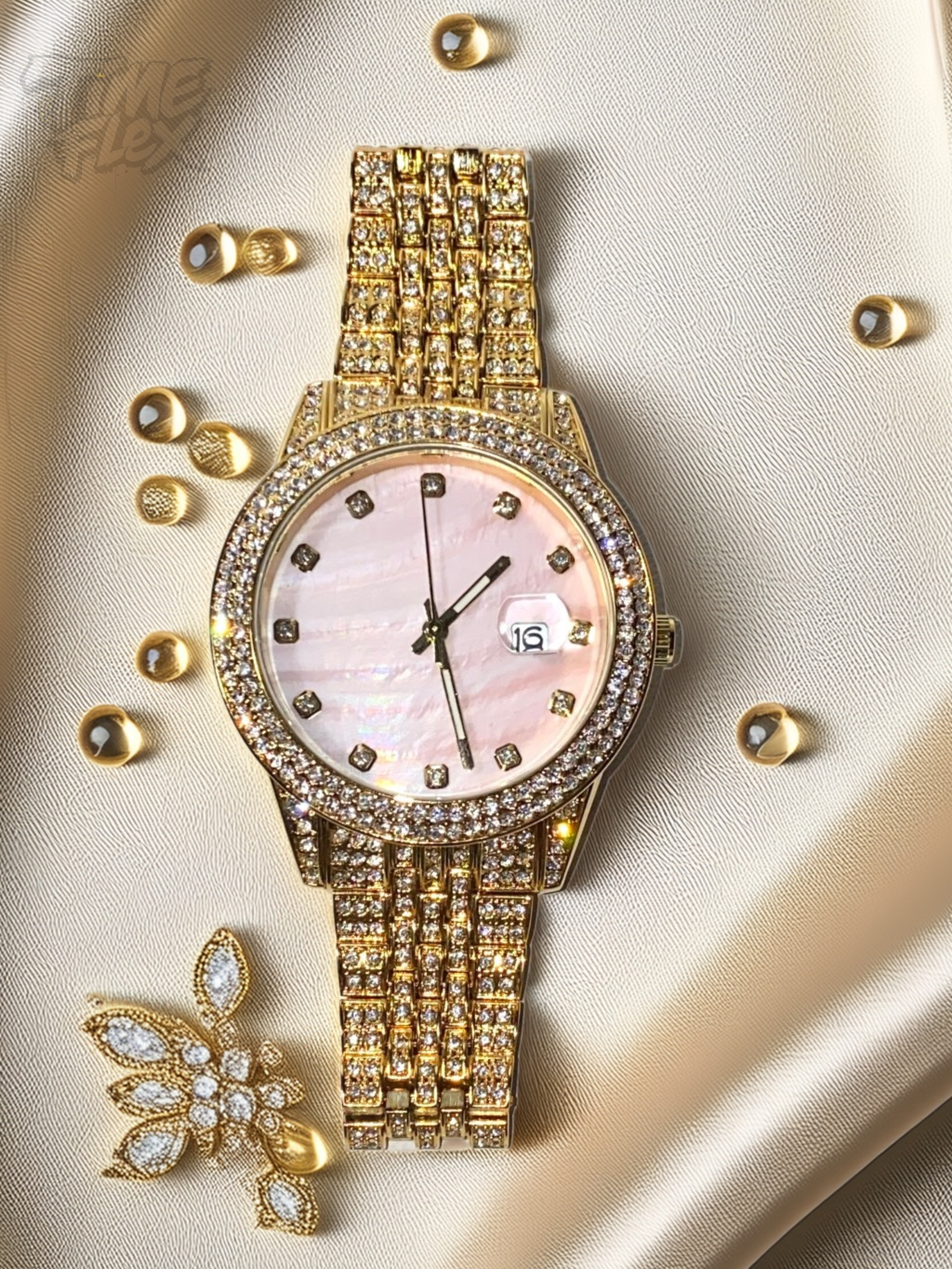 Gold-tone women's watch with a diamond-studded bezel, pink mother-of-pearl dial, and date display at the 3 o'clock position. The watch features a shimmering, crystal-encrusted gold band for a glamorous and luxurious look.