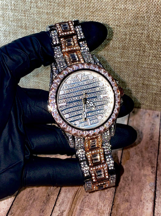Silver and gold men's women's watch with a diamond-studded bezel and rectangular stone accents on the band. The watch features a sleek white dial with black hands and a date display.
