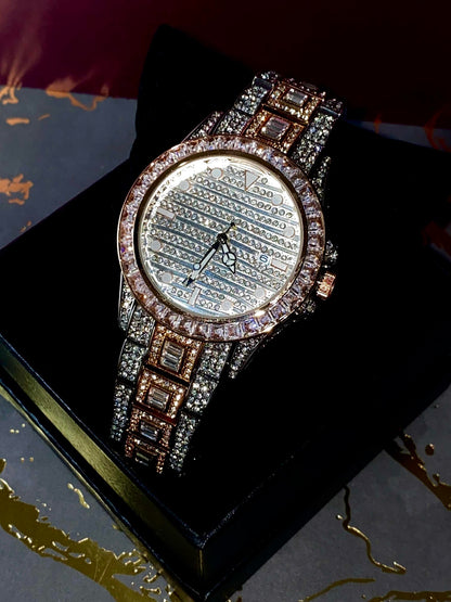 Silver and gold men's women's watch with a diamond-studded bezel and rectangular stone accents on the band. The watch features a sleek white dial with black hands and a date display.