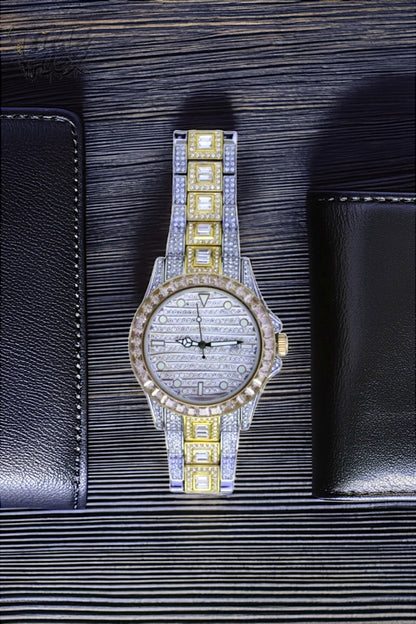 Silver and gold men's women's watch with a diamond-studded bezel and rectangular stone accents on the band. The watch features a sleek white dial with black hands and a date display.