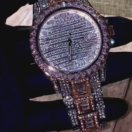 Silver and gold men's women's watch with a diamond-studded bezel and rectangular stone accents on the band. The watch features a sleek white dial with black hands and a date display.