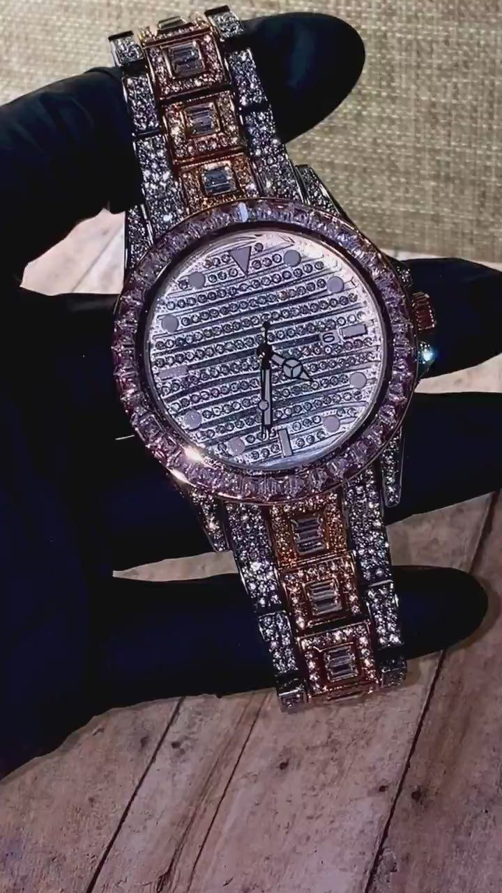 Silver and gold men's women's watch with a diamond-studded bezel and rectangular stone accents on the band. The watch features a sleek white dial with black hands and a date display.